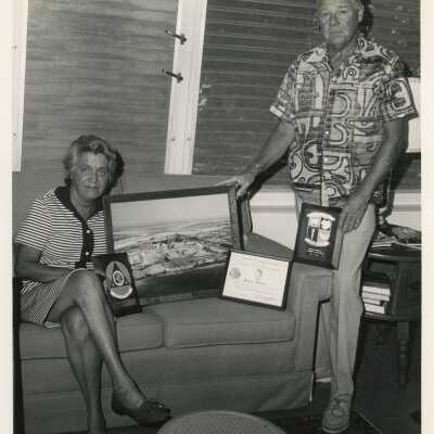 An unknown man and woman holding plaques