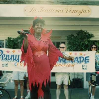 An unknown woman on a stage in front of the La Trattoria Venezia.