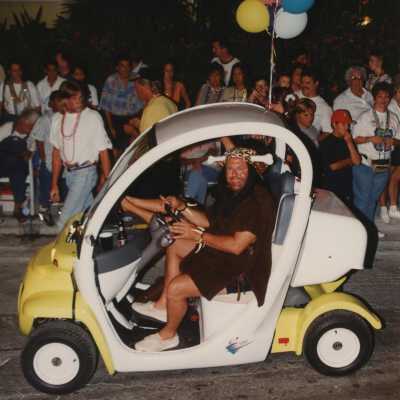 Unknown people in electric cars in the parade.