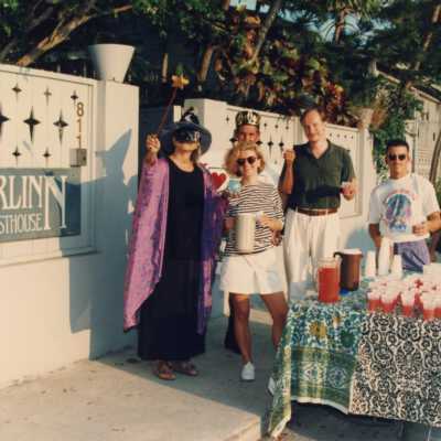 Unknown people standing in front of the Merlin Guesthouse during the Masquerade March.