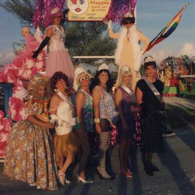 Unknown people dressed up standing next to a float.