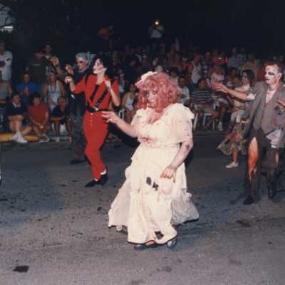 Unknown people dressed up walking in the street for the parade.