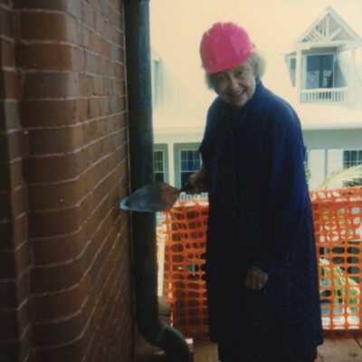Wilhelmina Harvey standing with a tool in her hand outside of the Custom House.