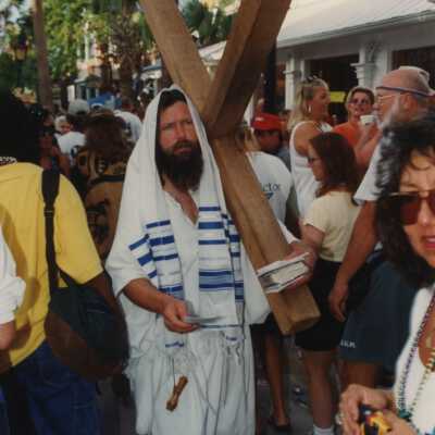 An unknown man carrying a wooden cross.