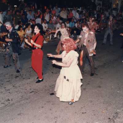 Unknown people dressed up walking in the street for the parade.