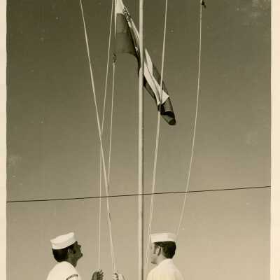 2 Men in uniform with a flag