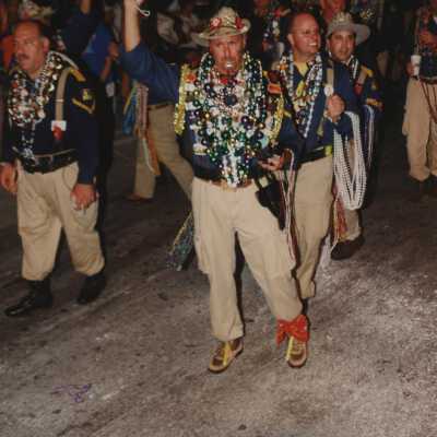 Unknown people dressed up walking in the street for the parade.
