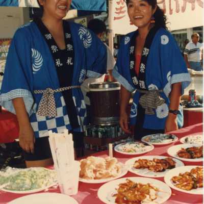 Two unknown woman working a food booth.