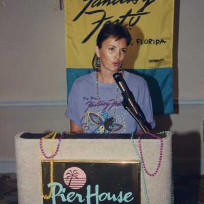 Unknown woman talking at the podium, at the Fantasy Fest meeting.