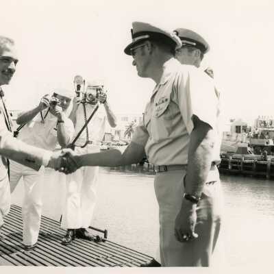 U.S. Navy men shaking hands with unknown man