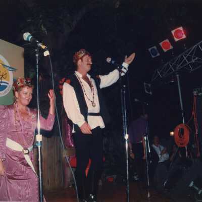 Two unknown people dressed up on a stage.