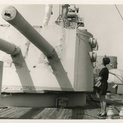An unknown woman looking at a few men on a machine