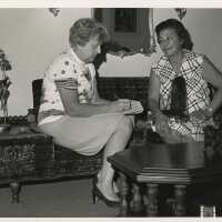 2 Unknown woman sitting on a couch and talking to each other