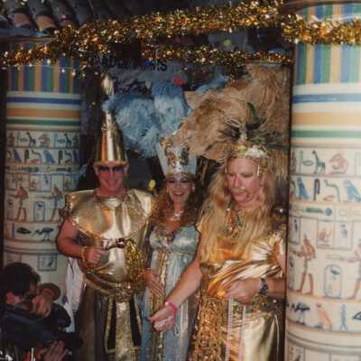 Three unknown people dressed up on a float for the parade.