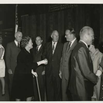 A group of unknown people at a party greeting each other