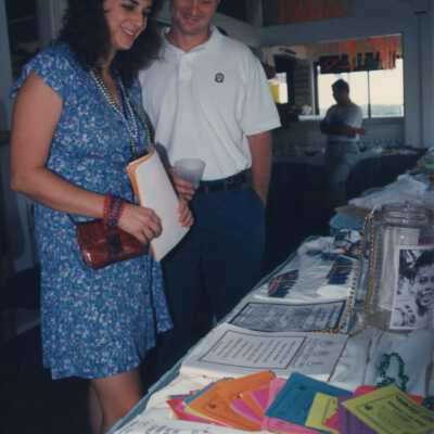 Unknown couple looking at stuff on a table.