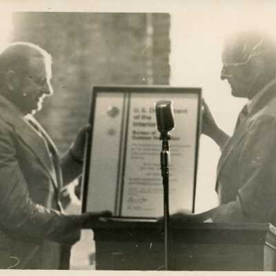 Unknown men holding an award