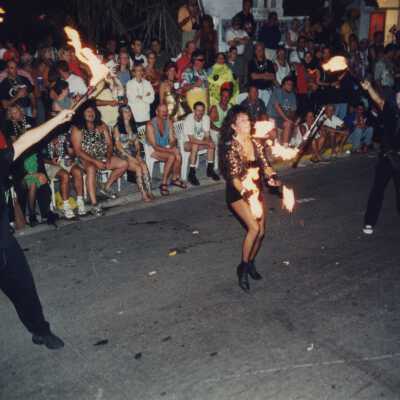 Unknown people dressed up juggling with fire in the parade.