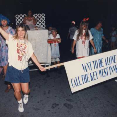 Unknown people dressed up walking down the street for the parade.