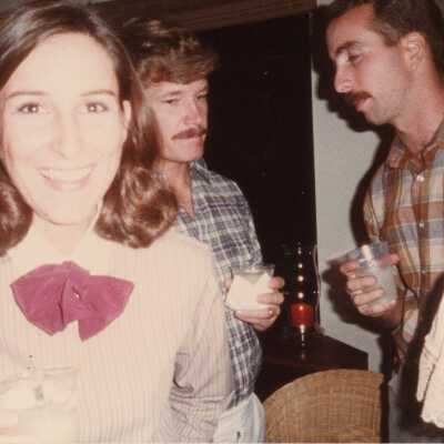 Unknown woman and 2 men at a party