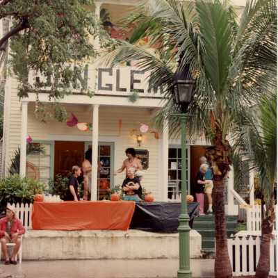 Unknown people standing in front of the Tropical Inn at 812 Duval Street talking.