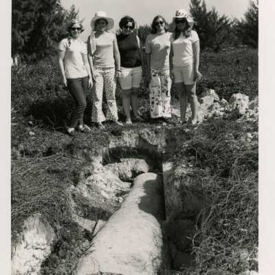 Unknown woman standing next to a pipe in the ground