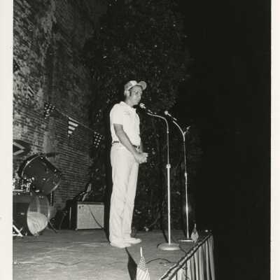 Unknown man standing at a microphone on stage