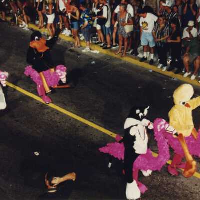 Unknown people dressed up walking in the street for the parade.