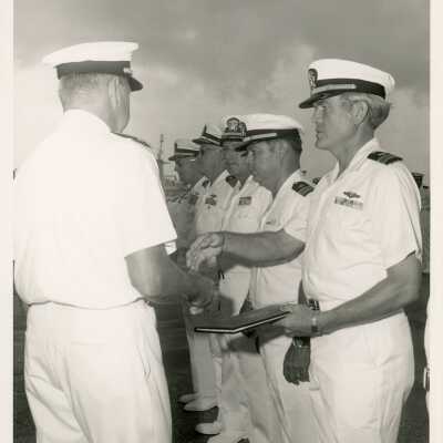 Men in uniform standing and one shaking hands with another