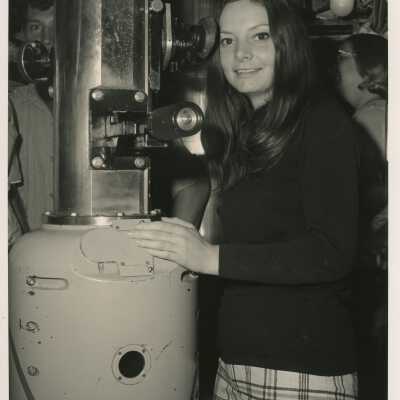 An unknown woman standing next to a machine