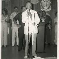 An unknown man speaking in a microphone at a ceremony