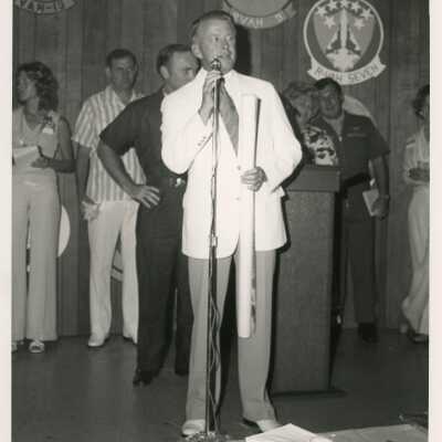 An unknown man speaking in a microphone at a ceremony