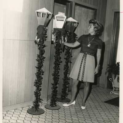 Unknown woman standing next to Christmas decorations