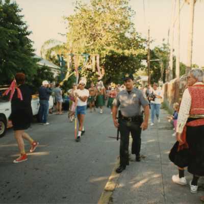 Unknown people dressed up walking down the street in a parade.