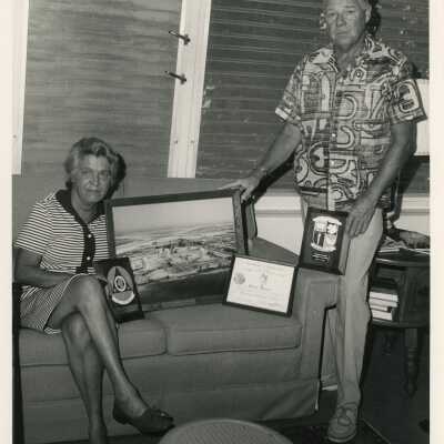 An unknown woman and man showing off a few awards