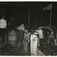A group of unknown men on a boat jumping on to another boat