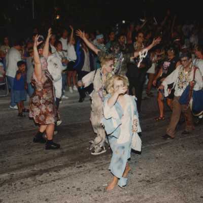 Unknown people dressed up walking in the street for the parade.
