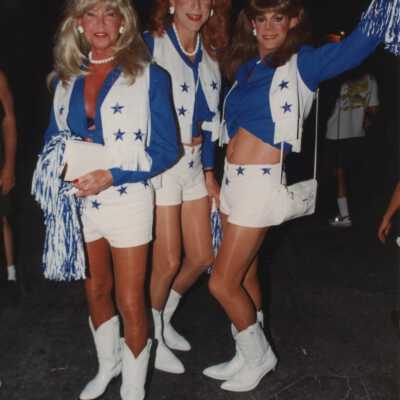 Three unknown people dressed up as cheerleaders.