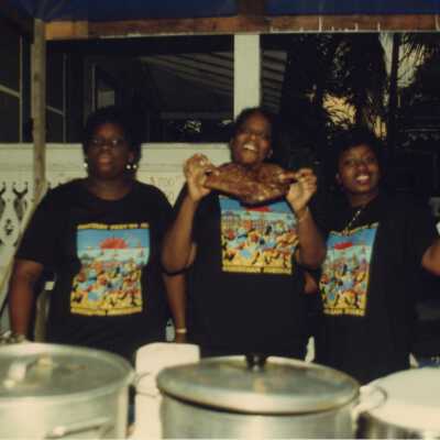 Three unknown woman working at a food booth at the Goombay celebration.