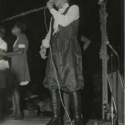 An Unknown woman singing into a microphone