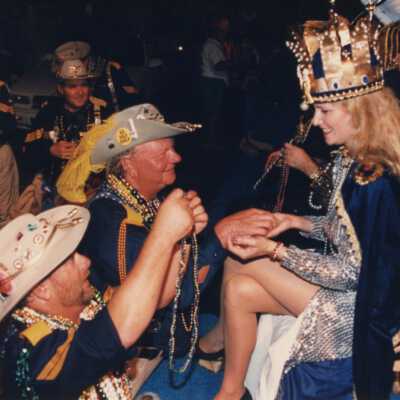 Unknown men giving the fantasy fest queen beads.