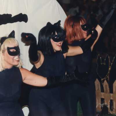Unknown woman dressed up as black cats on a float.