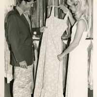 2 Unknown people looking at a dress