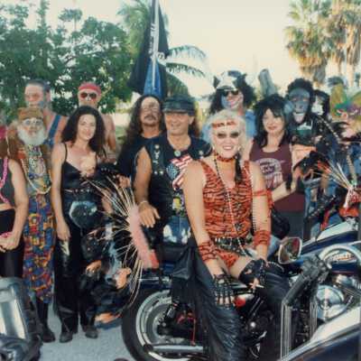 Unknown people standing with motorcycles.