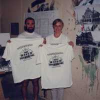 An unknown man and woman holding up t-shirts that have the Custom House on it.