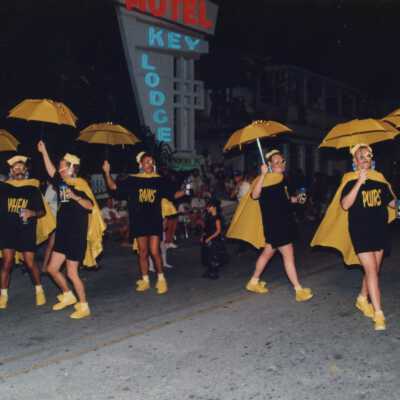 Unknown people dressed up walking in the street for the parade.