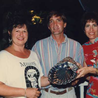 Rita Troxel with two unknown people holding an award at the awards ceremony.