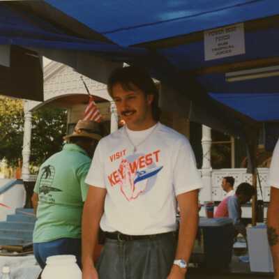 Unknown people standing a street fair stand.