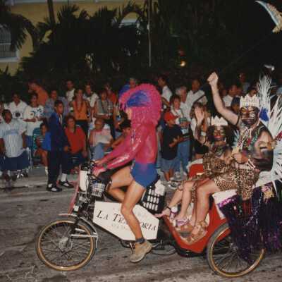 Unknown people dressed up on a pedi cab in the parade.