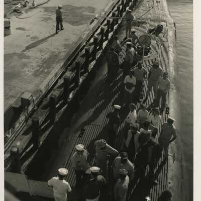A group of unknown people standing on a ship